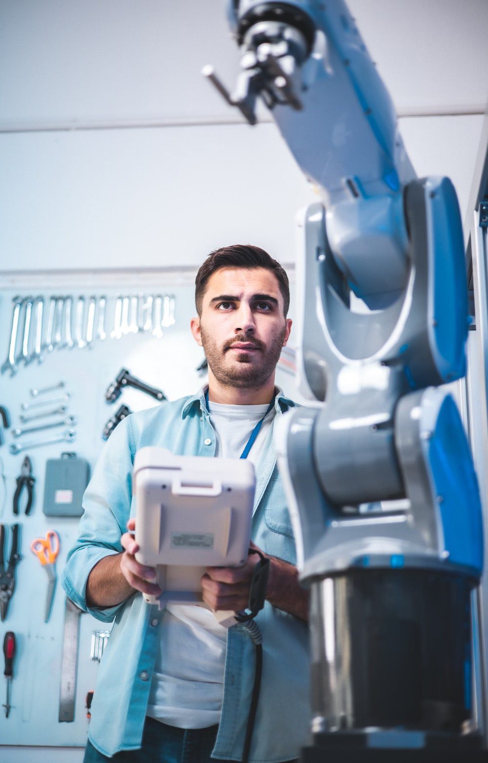 Developer with control panel in front of a robot arm